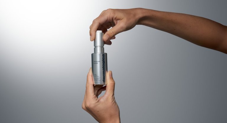 hands holding a bottle of Dermalogica FutureCode Booster serum